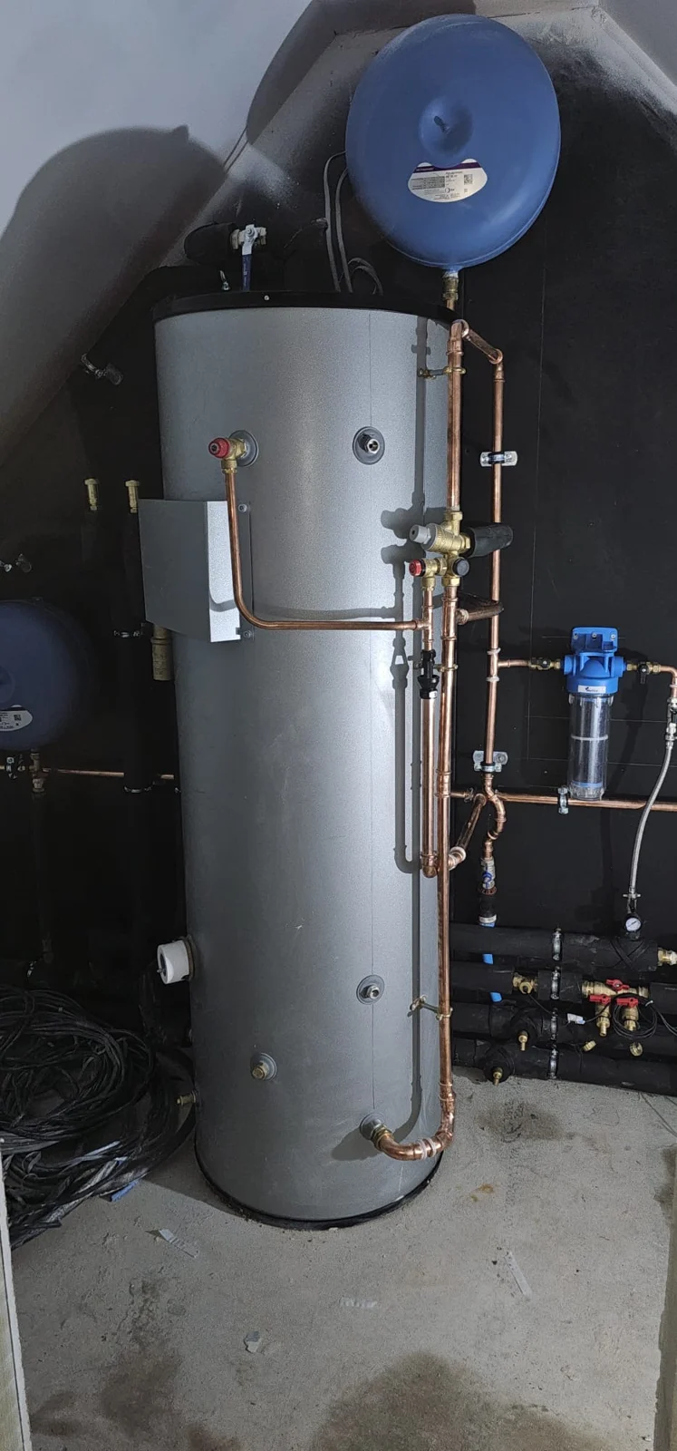 Hot water cylinder against dark backing panels
