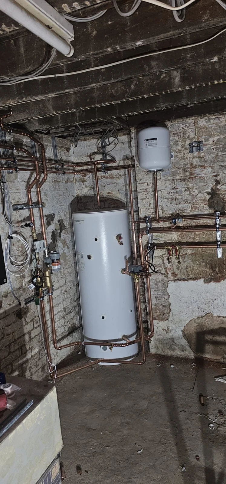 Cylinder and pipework in the exposed-brick plantroom