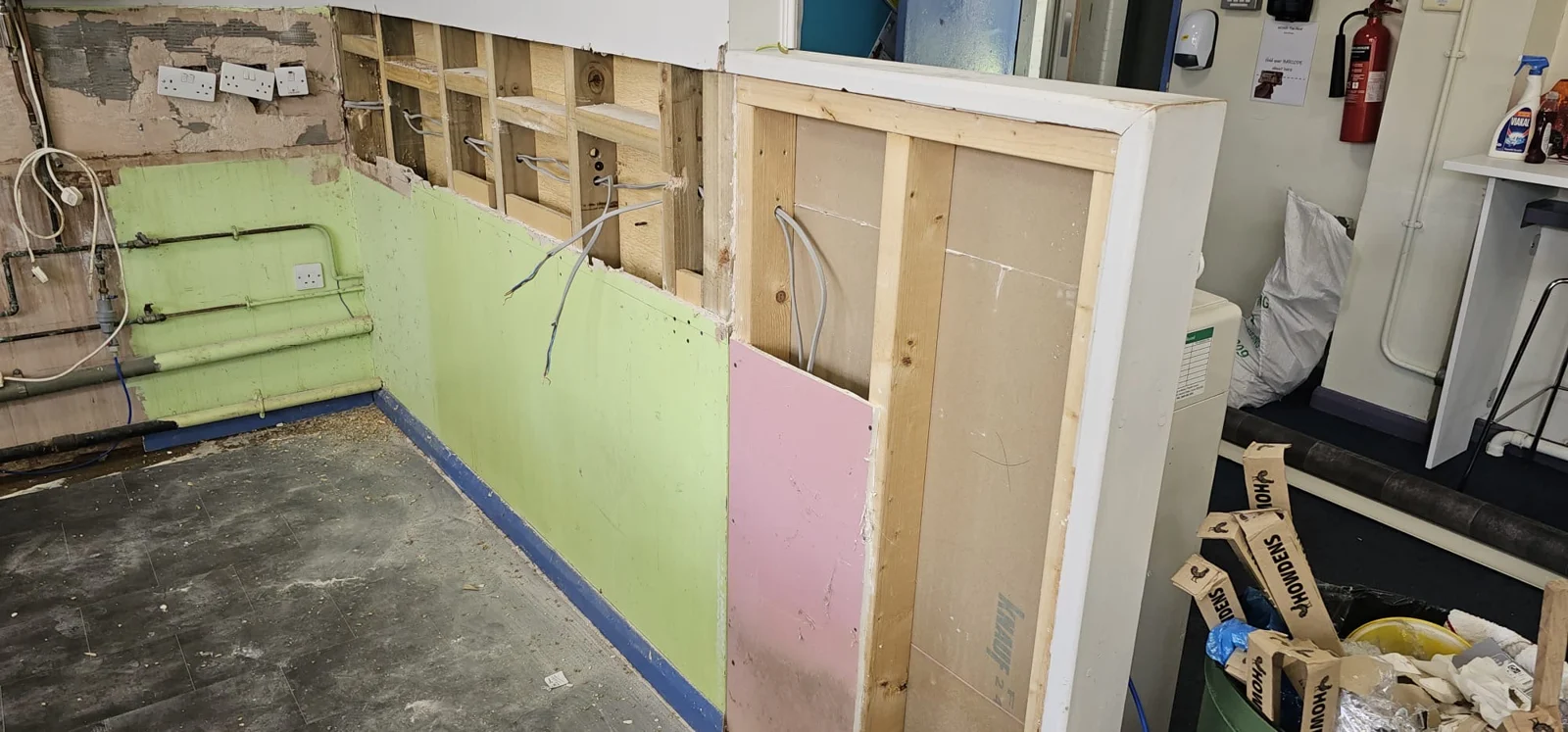 Exposed kitchen wall framing and pipework