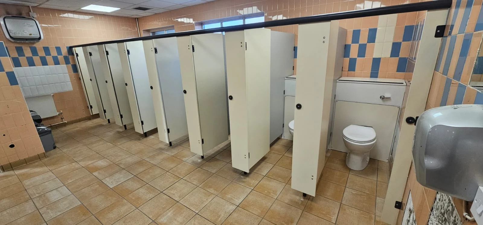 Row of cream toilet cubicles