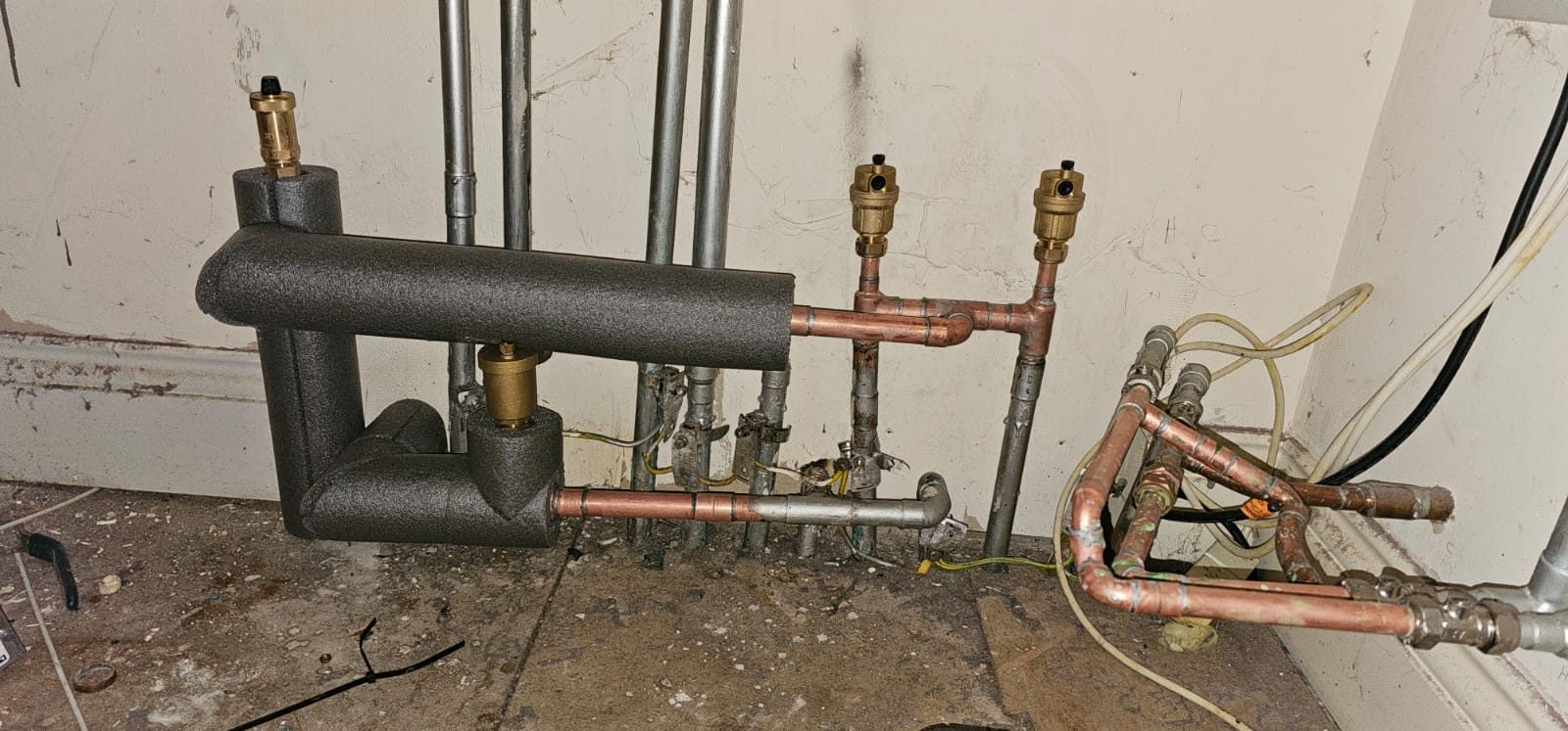 Insulated header pipework with copper branches and automatic air vents installed by Smart Eco Developments