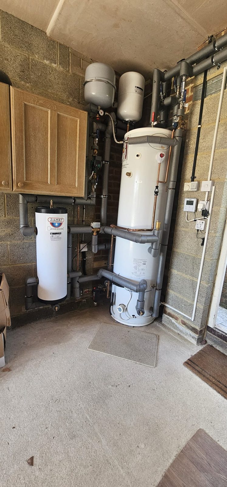 Hot water cylinder and buffer vessel with expansion vessels, pump and valves above
